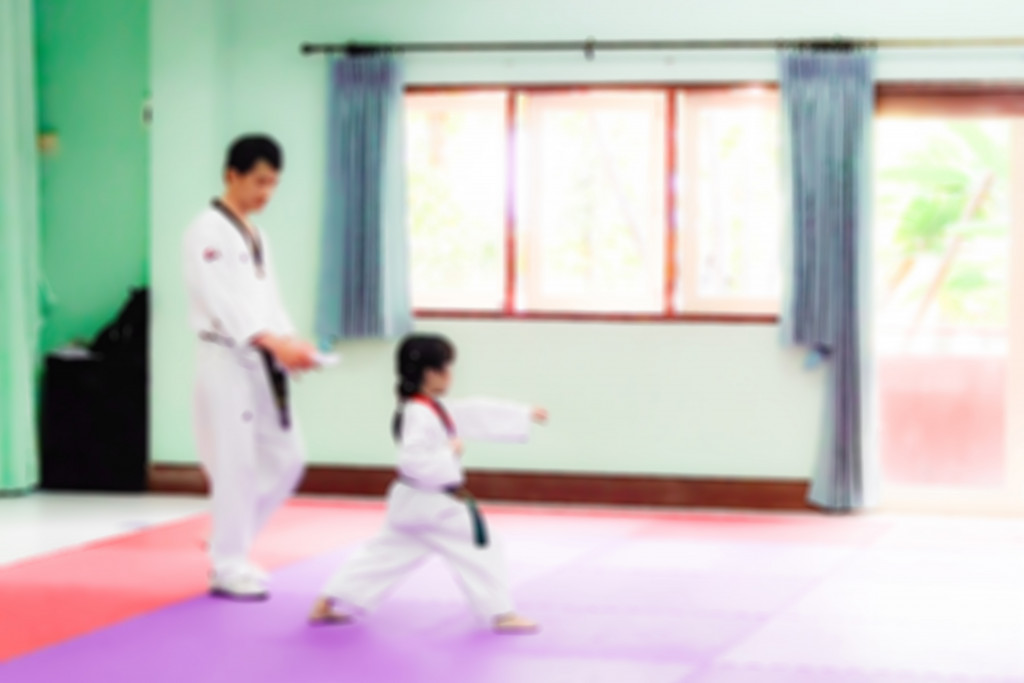 A taekwondo coach teaching a kid