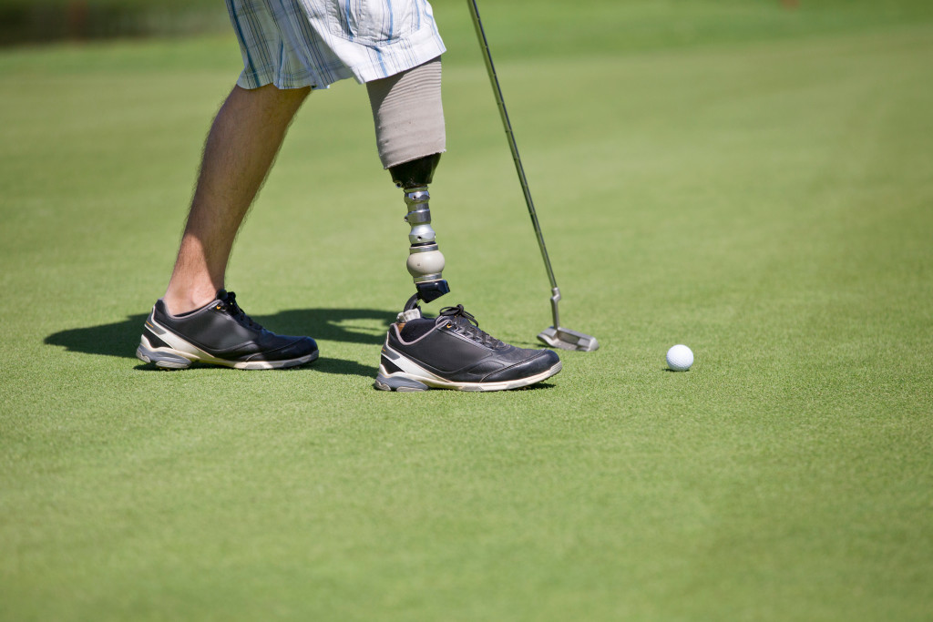 man with prosthetic leg is playing golf