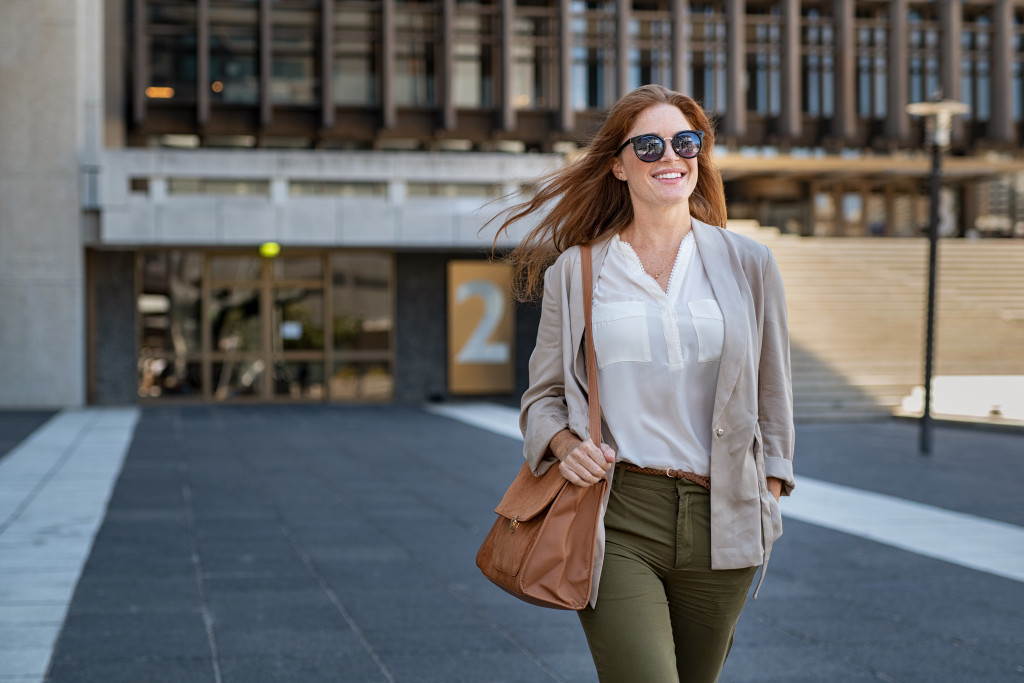 Young woman smiling while walking outside a building.
