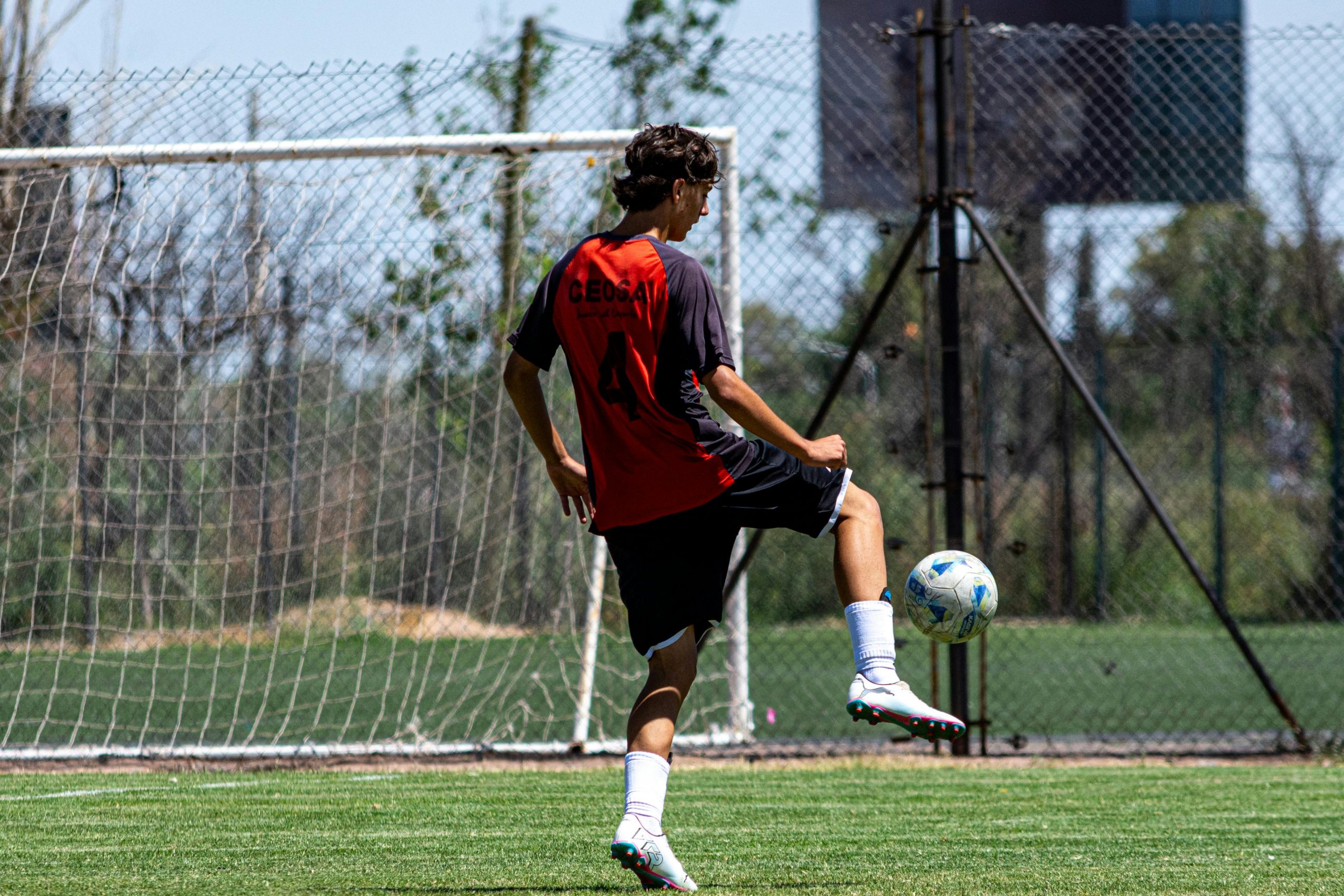 player practicing juggling a soccer ball on a field